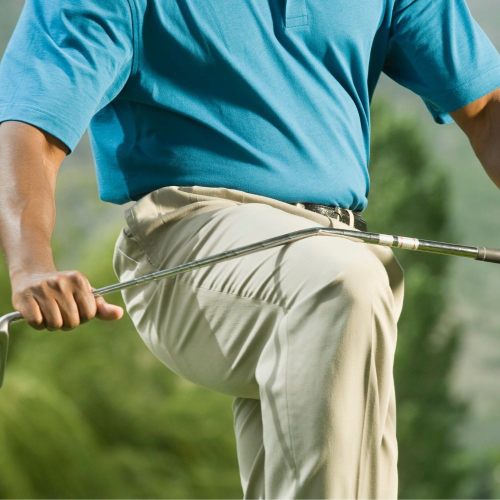 A golfer hitting a drive off the tee