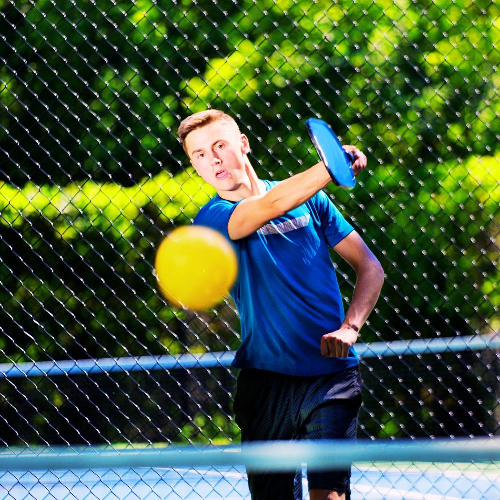 A pickleball player serving the ball
